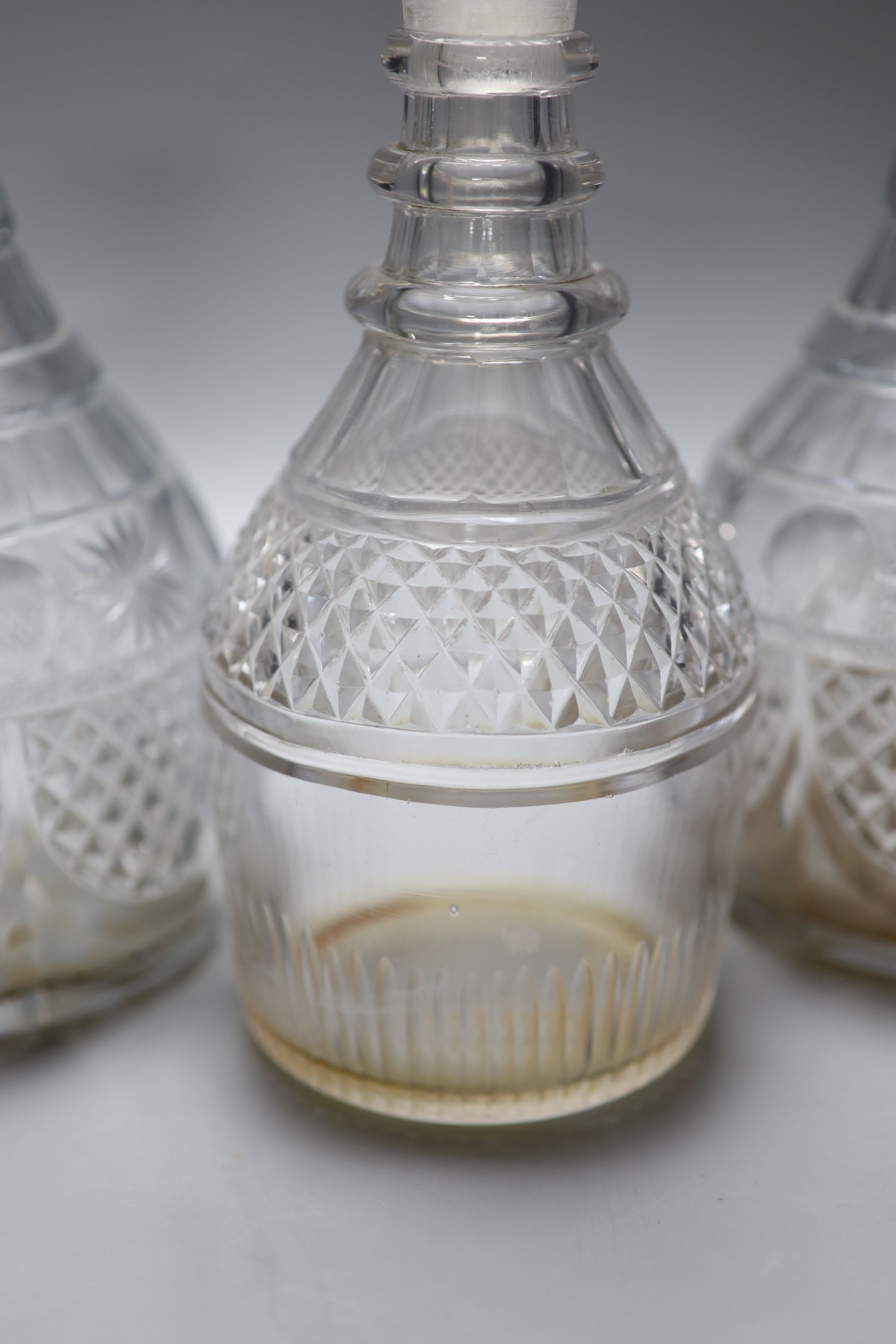 A pair of early 19th century cut glass decanters and one other